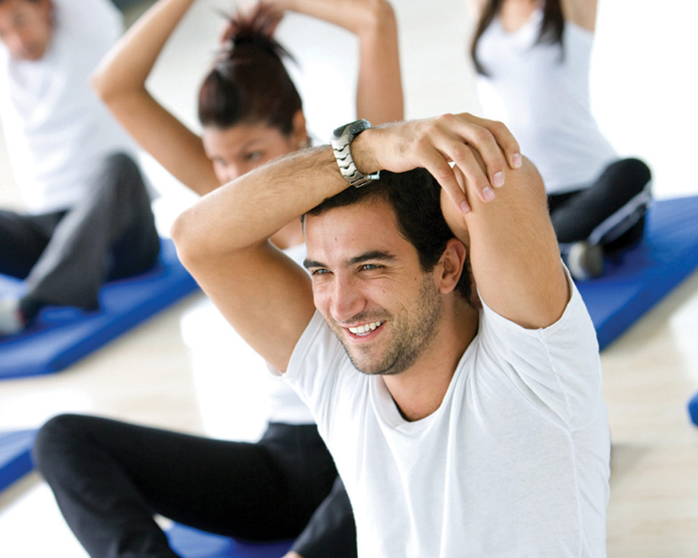 Smiling man in exercise class stretching