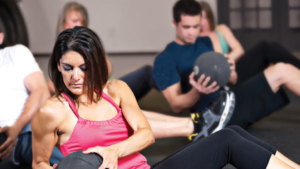 Group sitting and exercising with medicine balls