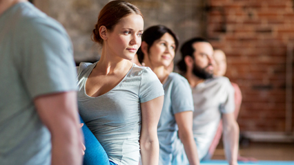 Group sitting on mat stretching