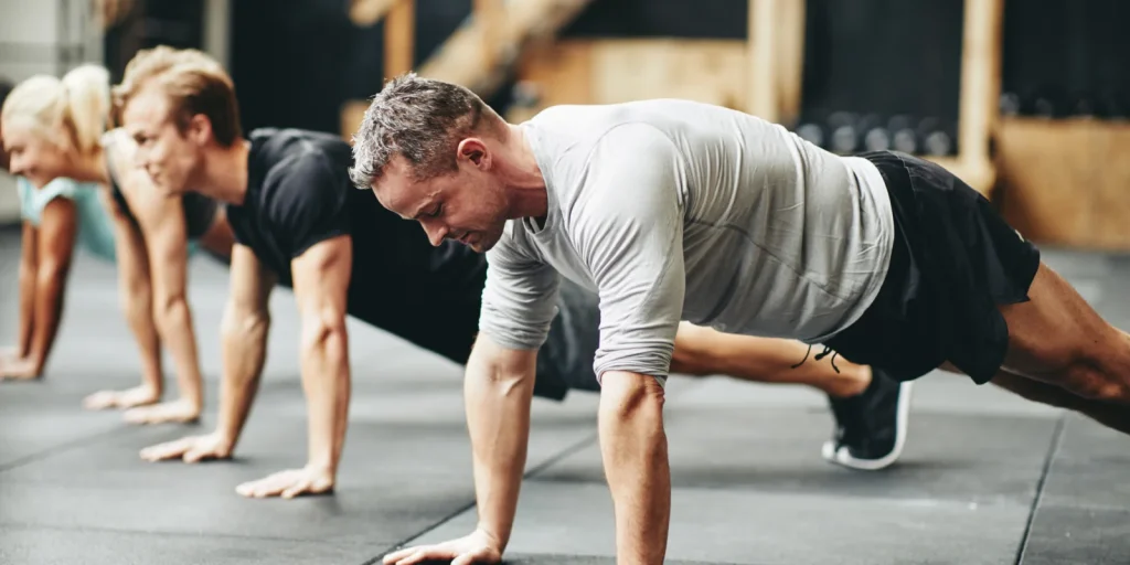 small group exercise class participants doing a plank