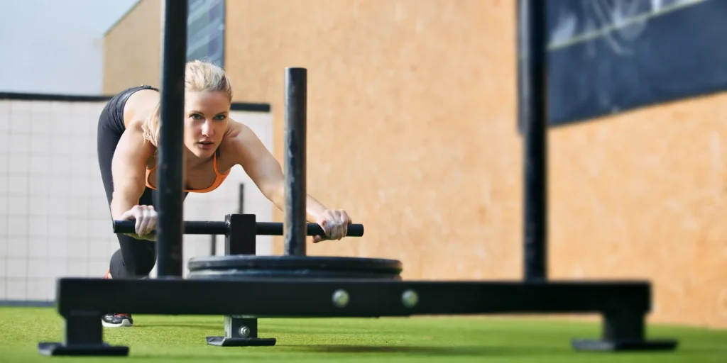 woman pushing weighted sled