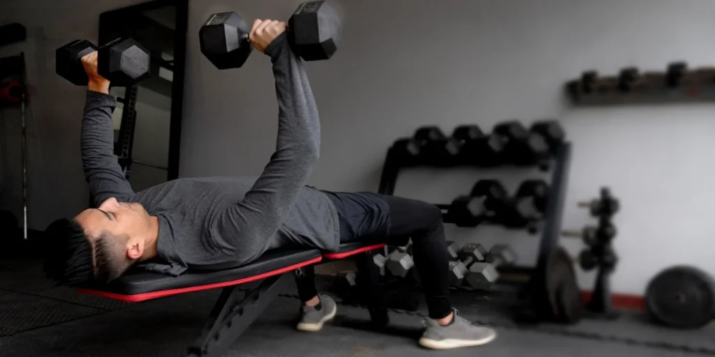 man in Zone Fitness lifting weights on a bench