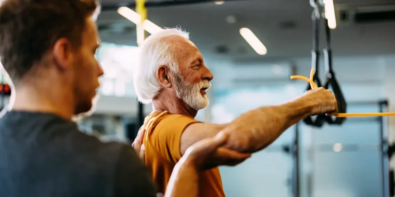 personal trainer with senior client doing resistance exercises