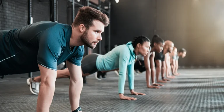 participants in a small group training class doing a plank